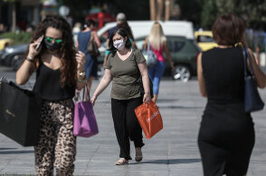 Πολίτες με μάσκα για τον κορωνοϊό περπατούν στο κέντρο της Αθήνας