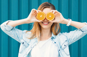 Κορίτσι που κρατάει ροδέλες πορτοκαλιού μπροστά στα μάτια της