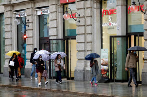 Κορωνοϊός στην Ιταλία: Κάτοικοι στο Μιλάνο περπατούν με προστατευτική μάσκα σε πεζοδρόμιο της πόλης