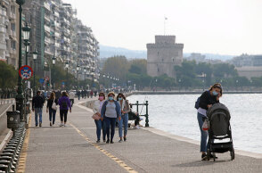 Πολίτες στη Θεσσαλονίκη περπατούν με μάσκα για τον κορωνοϊό