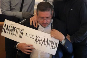 Ο πρύτανης της ΑΣΟΕΕ με την ταμπέλα που του κρέμασαν στον λαιμό οι κουκουλοφόροι