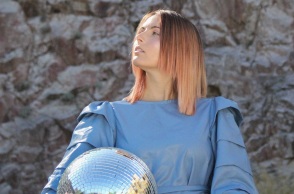 Κοπέλα με μπλε ρούχα και ξανθοχάλκινα μαλλιά με γυρισμένο πρόσωπο στα αριστερά