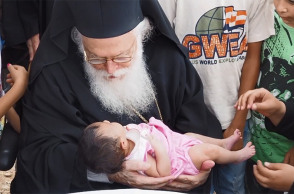 Ο Αρχιεπίσκοπος Αναστάσιος και ένα προσφυγόπουλο από το Κομπάνι