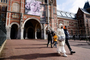 Πολίτες με μάσκα για τον κορωνοϊό περπατούν στο Άμστερνταμ