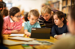 Ομάδα παιδιών και δασκάλων μπροστά σε υπολογιστή