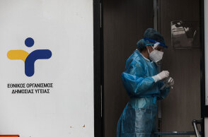 Εργαζόμενη σε κλιμάκιο του ΕΟΔΥ με προστατευτική στολή και μάσκα για τον κορωνοϊό διενεργεί rapid test