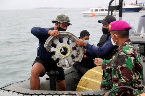 Διασώστες βγάζουν από τη θάλασσα ένα κομμάτι από τη ρόδα του αεροσκάφους της Sriwijaya Air, το οποίο συνετρίβη στην Ινδονησία