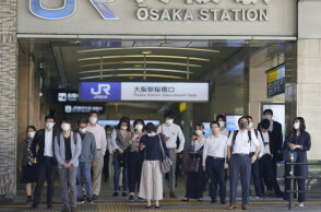 Πολίτες στην Ιαπωνία με μάσκα για τον κορωνοϊό περιμένουν το τρένο