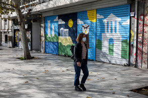Γυναίκα με μάσκα για τον κορωνοϊό στο κέντρο της Αθήνας - Στο πίσω μέρος κλειστό κατάστημα λόγω lockdown για τον κορωνοϊό