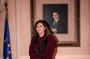 Η Mιμή Ντενίση με φόντο πορτραίτο του Αντώνη Τρίτση στο Δημαρχείο Αθηνών