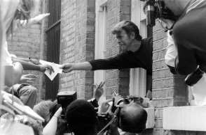 Ο Ντέιβιντ Μπόουι απλώνει το χέρι του από το παράθυρο του σπιτιού του σε θαυμαστές