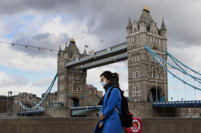 Κορωνοϊός στη Μεγάλη Βρετανία: Κοπέλα φορά μάσκα για Covid-19 με φόντο τη Γέφυρα του Λονδίνου