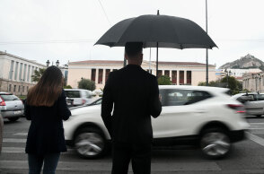 Lockdown στην Αττική: Νεαρός με ομπρέλα στη βροχερή Αθήνα
