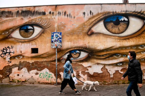 Ιταλία - Κορωνοϊός: Γυναίκα με μάσκα βγάζει βόλτα τον σκύλο στη συνοικία Τραστέβερε στη Ρώμη