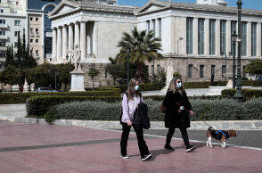 Lockdown για τον κορωνοϊό στην Αττική - Κοπέλα με μάσκα περπατά δίπλα σε γυναίκα που έχει βγάλει βόλτα το σκύλο της