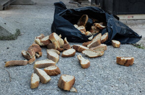 Ανοιγμένη σακούλα με φέτες ψωμί δίπλα από κάδο απορριμμάτων - Στην Ελλάδα φαγητό και τρόφιμα πετιούνται κάθε χρόνο χωρίς να καταναλωθούν