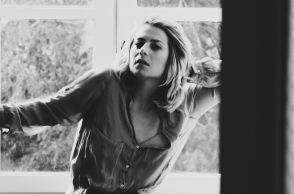 Ασπρόμαυρη γυναίκα που απεικονίζει γυναίκα να στέκεται μπροστά από το παράθυρο