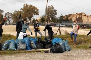 Οκτώ εθελοντές της ομάδας Save Your Hood με γεμάτες σακούλες σκουπιδιών
