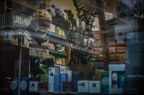 Φαρμακοποιός με μάσκα για τον κορωνοϊό σε φαρμακείο