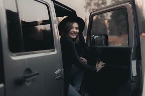 Κοπέλα με μαύρα ρούχα και καπέλο στο αυτοκίνητο