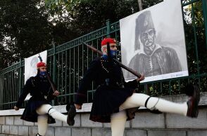 Εύζωνες της Προεδρικής Φρουράς μπροστά από την υπαίθρια έκθεση προσωπογραφιών ηρώων της επανάστασης του 1821 στην περίφραξη του Εθνικού Κήπου