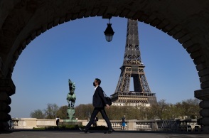 Γαλλία: Πολίτης με μάσκα περπατά με φόντο τον Πύργο του Άιφελ 