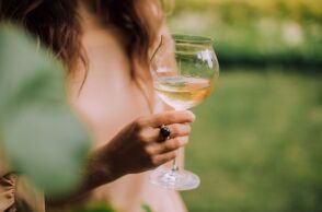 Γυναίκα που κρατάει ένα ποτήρι λευκό κρασί