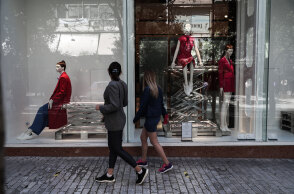 Κοπέλες περνούν έξω από εμπορικό κατάστημα στην Ερμού