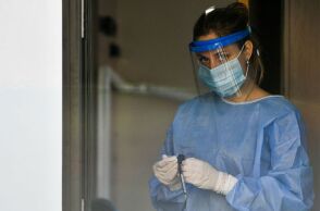 Υγειονομικός του ΕΟΔΥ με μάσκα για τον κορωνοϊό ετοιμάζει rapid test