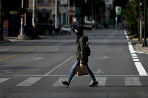 Κορωνοϊός - Ελλάδα: Γυναίκα με μάσκα διασχίζει διάβαση πεζών στην Αθήνα