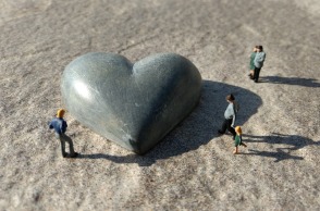 Μινιατούρες ανθρώπων γύρω από γλυπτή καρδιά