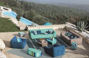 Καναπέδες και τραπέζια σε εξωτερικό χώρο με φόντο δέντρα