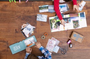 Ξύλινο τραπέζι με τυπωμένες φωτογραφίες και ανθρώπους που πιάνουν πράγματα