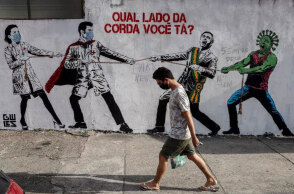 Βραζιλία: Άνδρας με μάσκα περνά μπροστά από γκράφιτι για τον κορωνοϊό - Δεύτερη παγκοσμίως σε συνολικά θύματα της πανδημίας Covid-19