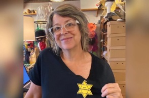 Γυναίκα φορά αυτοκόλλητο κίτρινο αστέρι με την ένδειξη «Δεν είμαι εμβολιασμένος»