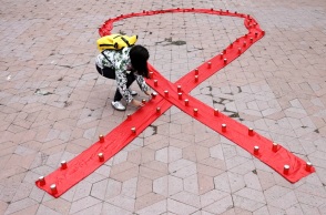 Ακτιβίστρια στη Σερβία σχηματίζει με κεριά την κορδέλα-σύμβολο για τον ιό HIV