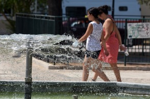 Καύσωνας - Γυναίκες περπατούν μπροστά από σιντριβάνι