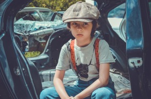 Παιδί με μπερέ που κάθεται σε αυτοκίνητο