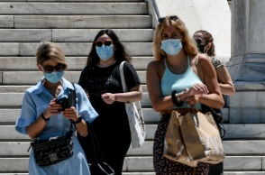 Κορωνοϊός: Γυναίκες φορούν τις μάσκες προστασίας και περπατούν στο κέντρο της Αθήνας