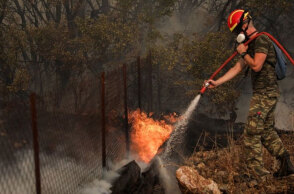Πυροσβέστης ρίχνει νερό σε φωτιά (ΦΩΤΟ ΑΡΧΕΙΟΥ)