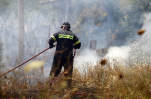 Πυροσβέστης ρίχνει νερό σε φωτιά (ΦΩΤΟ ΑΡΧΕΙΟΥ) - Συναγερμός σε Αττική και Εύβοια καθώς είναι ακραίος ο κίνδυνος πυρκαγιάς την Κυριακή 22 Αυγούστου 2021