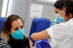 Γυναίκα με μάσκα για τον κορωνοϊό κάνει το εμβόλιο για την Covid-19 