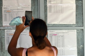 Γυναίκα φωτογραφίζει με το κινητό της τηλέφωνο τις βαθμολογίες των υποψηφίων των πανελλαδικών εξετάσεων 