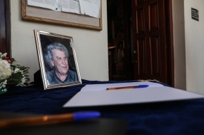Mια φωτογραφία του Μίκη Θεοδωράκη με φόντο το βιβλίο συλληπτηρίων στην κηδεία του στα Χανιά Κρήτης