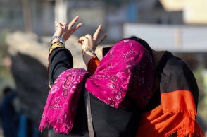 Γυναίκα με μαντήλα βγάζει σέλφι φωτογραφία σχηματίζοντας το σήμα της νίκης