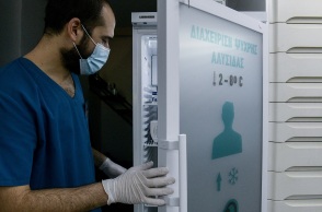 Φαρμακοποιός που ανοίγει ψυγείο φαρμακείου