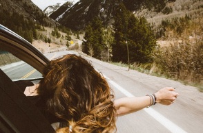 Μια κοπέλα βγάζει το χέρι από το παράθυρο κατά τη διάρκεια ενός roadtrip. 