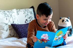 Παιδί στο κρεβάτι που διβάζει βιβλίο