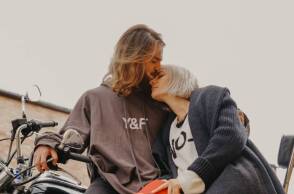 Άντρας φιλάει τη γυναίκα στο μέτωπο ενώ σκέκονται πάνω στη μηχανή