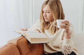 Νεαρή κοπέλα στον καναπέ, διαβάζει βιβλίο